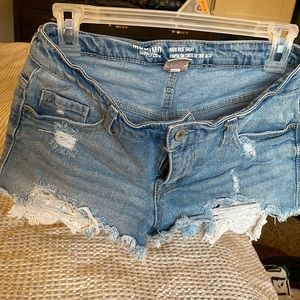 Denim shorts with distressing and lace detail